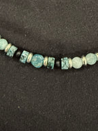 Close-up of blue-green gemstones, black onyx and silver accents