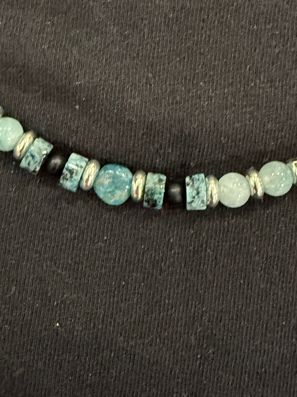 Close-up of blue-green gemstones, black onyx and silver accents