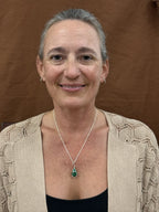 Wrapped emerald pendant necklace on a silver chain shown worn