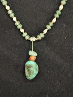 Close-up of turquoise pendant with aventurine and red carnelian accents