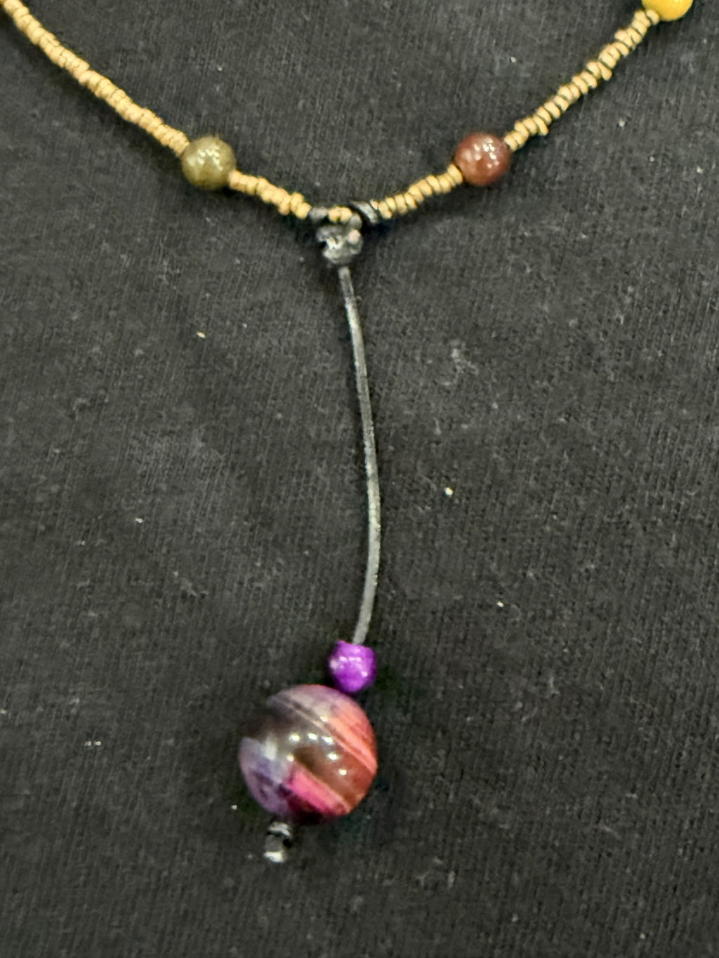 Close-up of leather cord drop and purple tiger’s eye bead on copper and mookaite choker