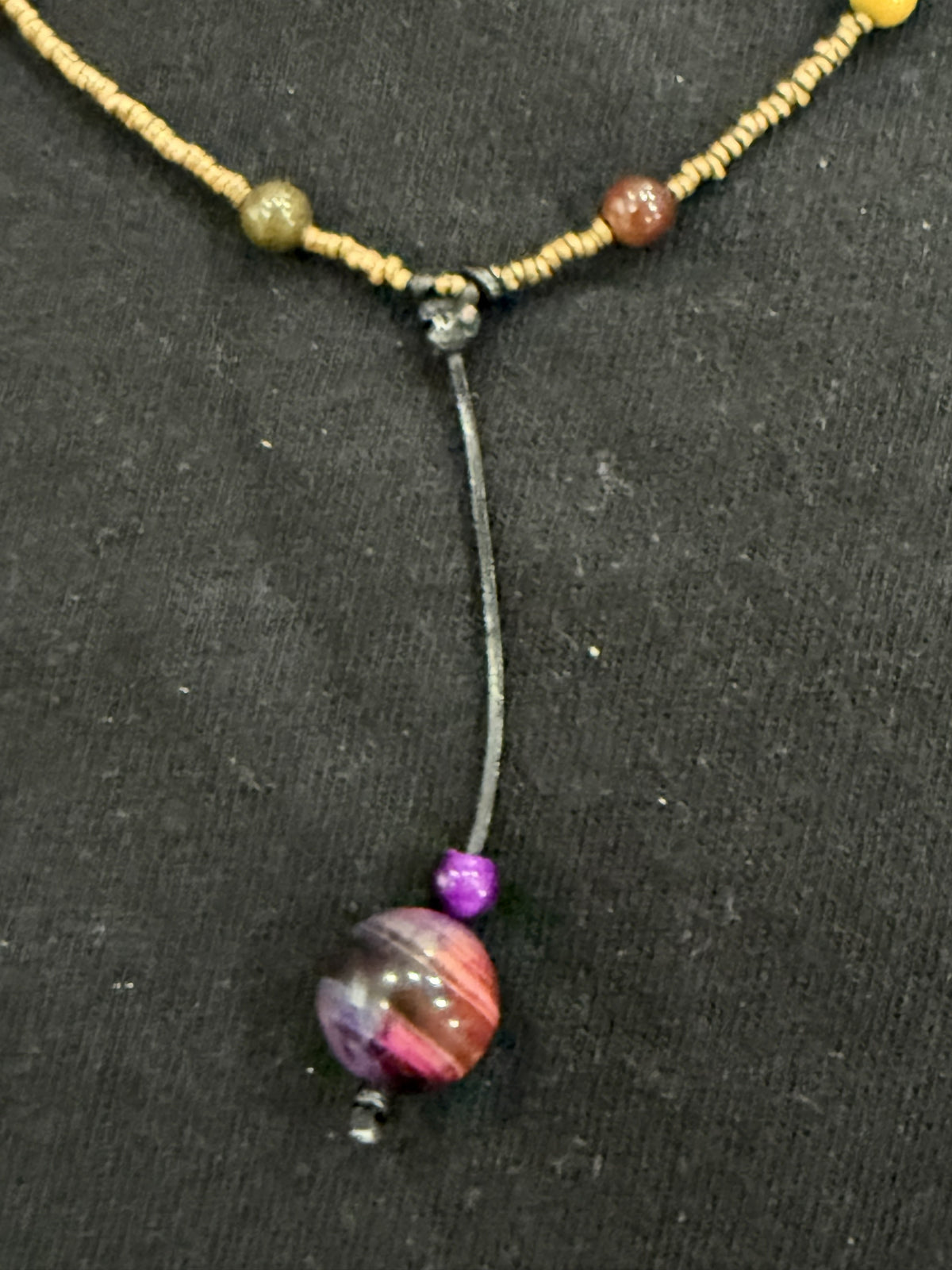Close-up of leather cord drop and purple tiger’s eye bead on copper and mookaite choker