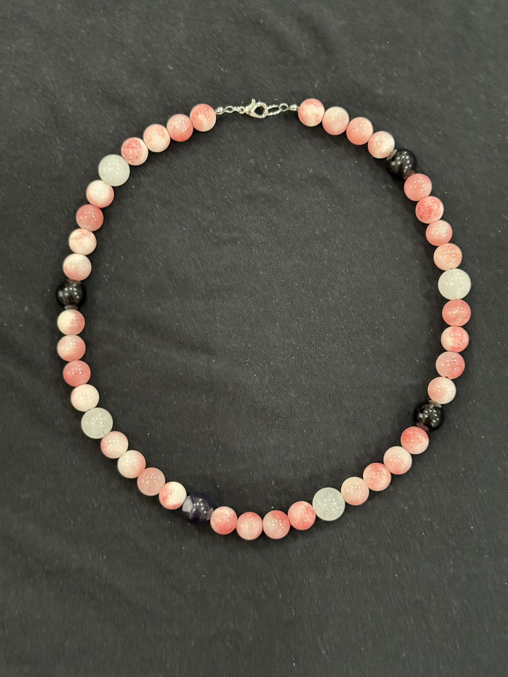 Full view of pink jade necklace with white quartz and black onyx accent beads
