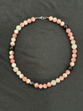Full view of pink jade necklace with white quartz and black onyx accent beads