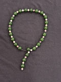 Full view of green jade and tourmaline waterfall necklace with exposed leather cord detail