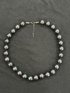 Close-up of lustrous Tahitian cultured pearls and knots in the leather cord