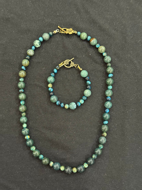 Matching beaded necklace and bracelet in green and teal shades with gold-tone toggle clasps.